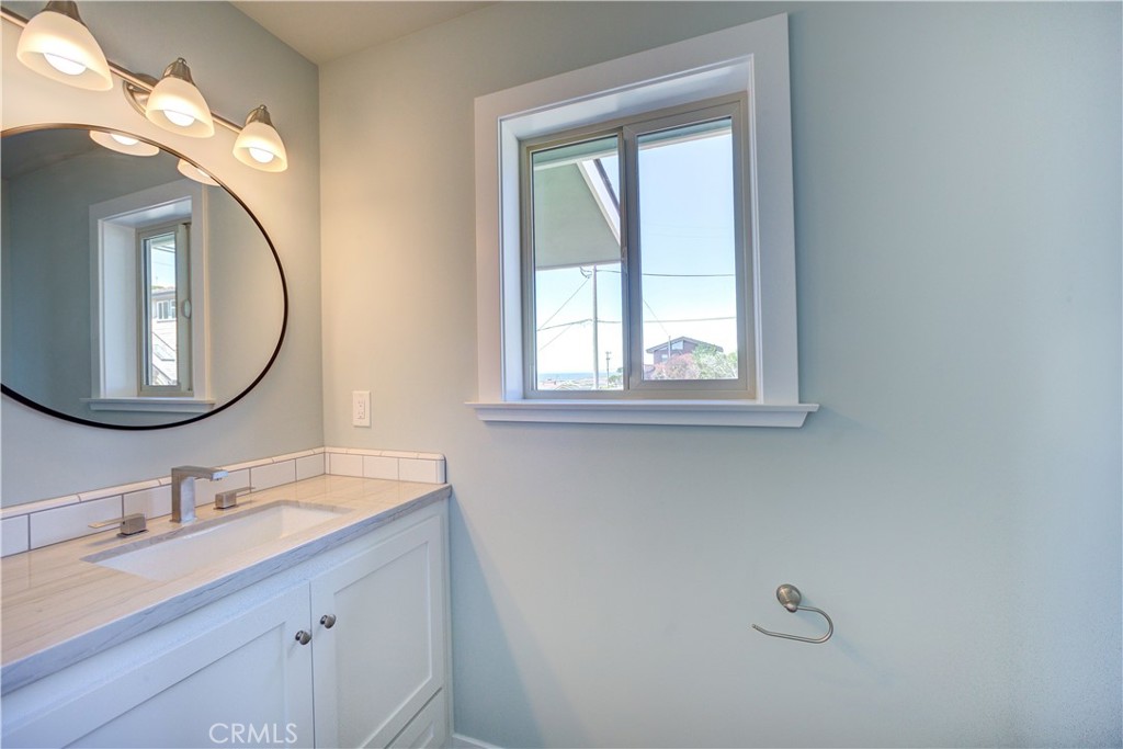 396 Castle Street Cambria, CA 93428 - Photo 43 of 74 a bathroom with a double vanity sink and a mirror