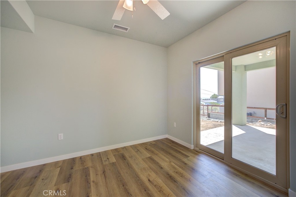 396 Castle Street Cambria, CA 93428 - Photo 55 of 74 an empty room with wooden floor and windows