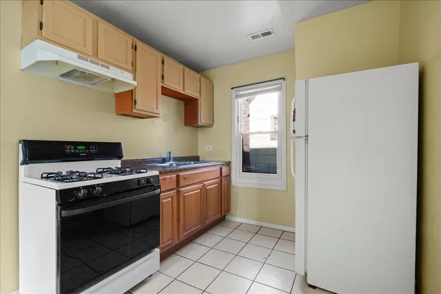 a kitchen with stainless steel appliances granite countertop a stove a sink and a refrigerator
