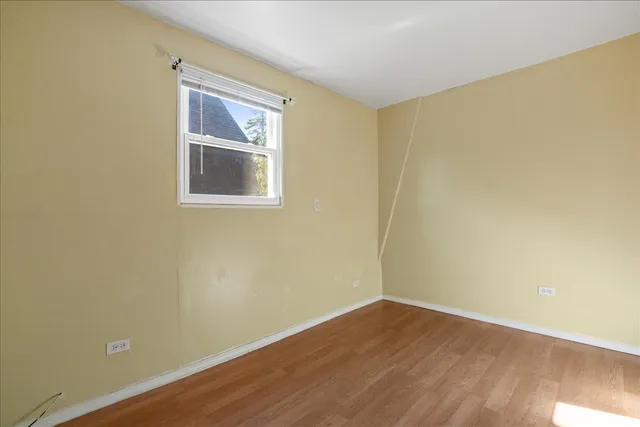 a view of a small space with wooden floor and a window