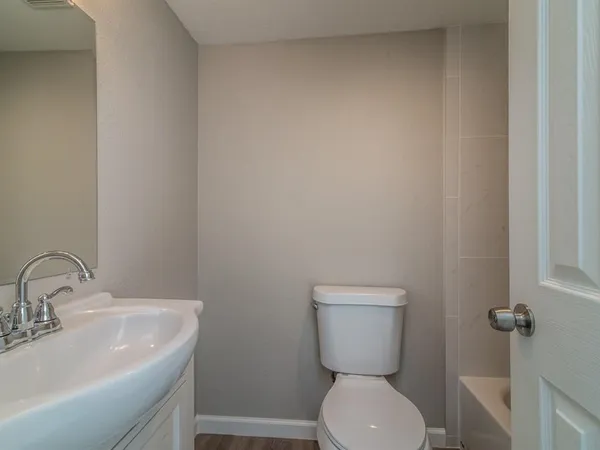a bathroom with a toilet sink and mirror