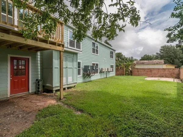 a view of a house with backyard and a tree