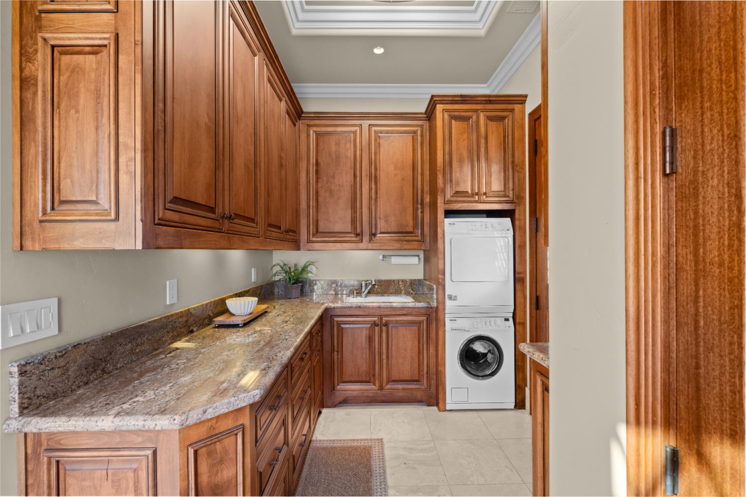 1100 Cold Springs Road Placerville, CA 95667 - Photo 23 of 97 Laundry room featuring rich wood cabinetry, stone countertops, undermount sink, under-cabinet lighting, and tile flooring