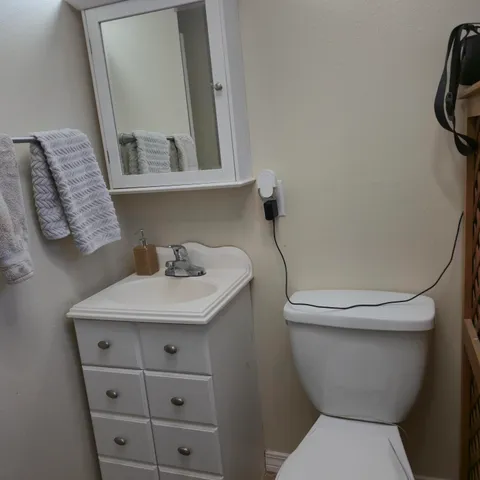 a bathroom with a toilet sink and mirror