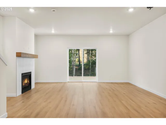 a view of an empty room with a fireplace and a window