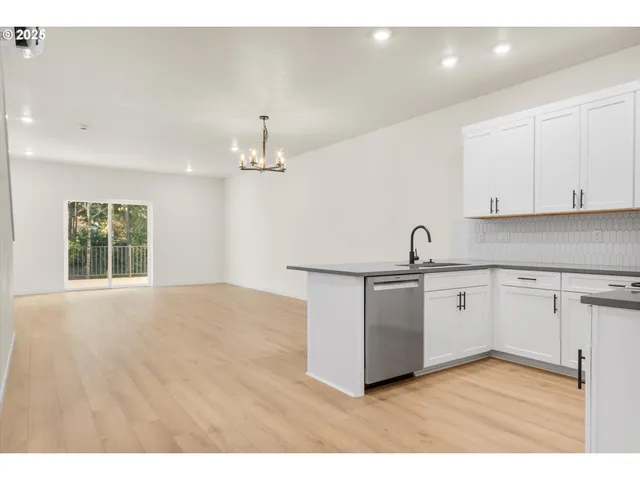 a kitchen with stainless steel appliances granite countertop white cabinets a sink and dishwasher
