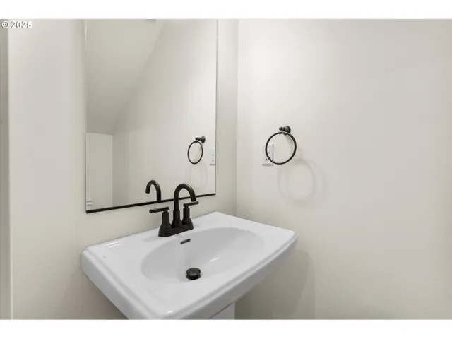 a kitchen with stainless steel appliances granite countertop a sink a stove a refrigerator and white cabinets