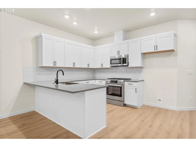 a kitchen with stainless steel appliances granite countertop a sink and a stove