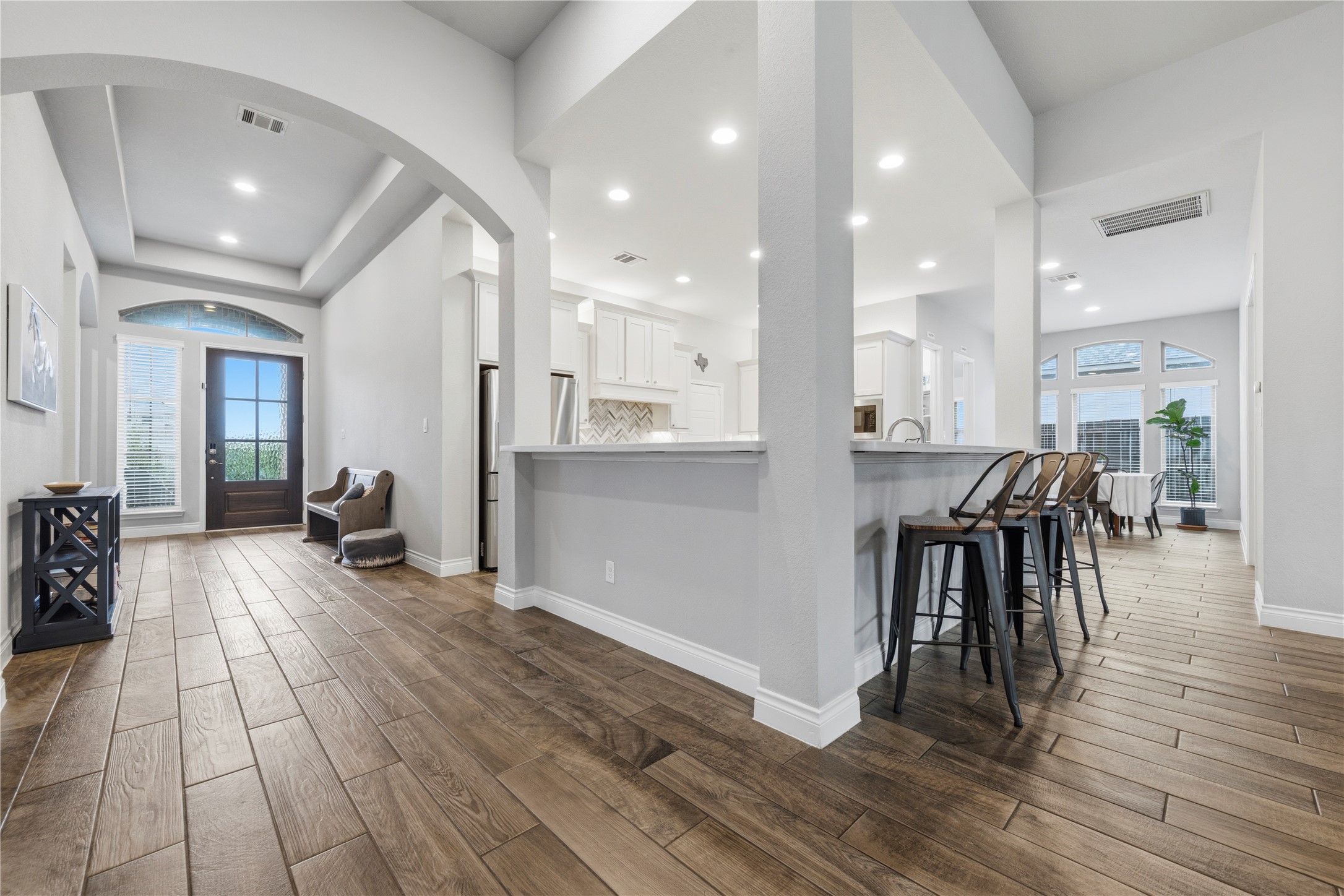 140 Catani Loop Georgetown, TX 78628 - Photo 12 of 36 Hardwood floors flow through an inviting entryway, leading to a spacious kitchen with a convenient breakfast bar.