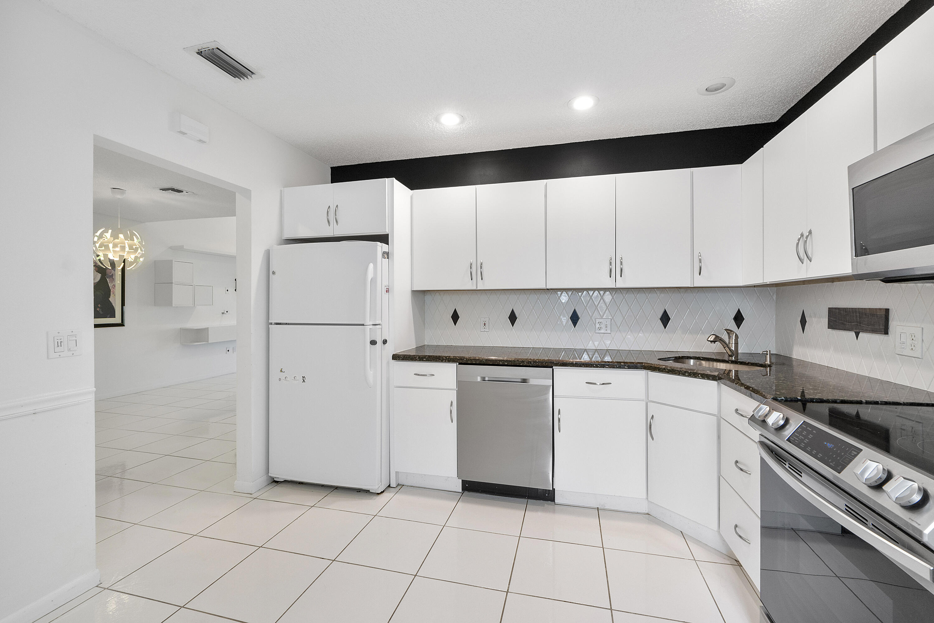 5153 Floria Drive, Unit V Boynton Beach, FL 33437 - Photo 11 of 39 a kitchen with cabinets and appliances