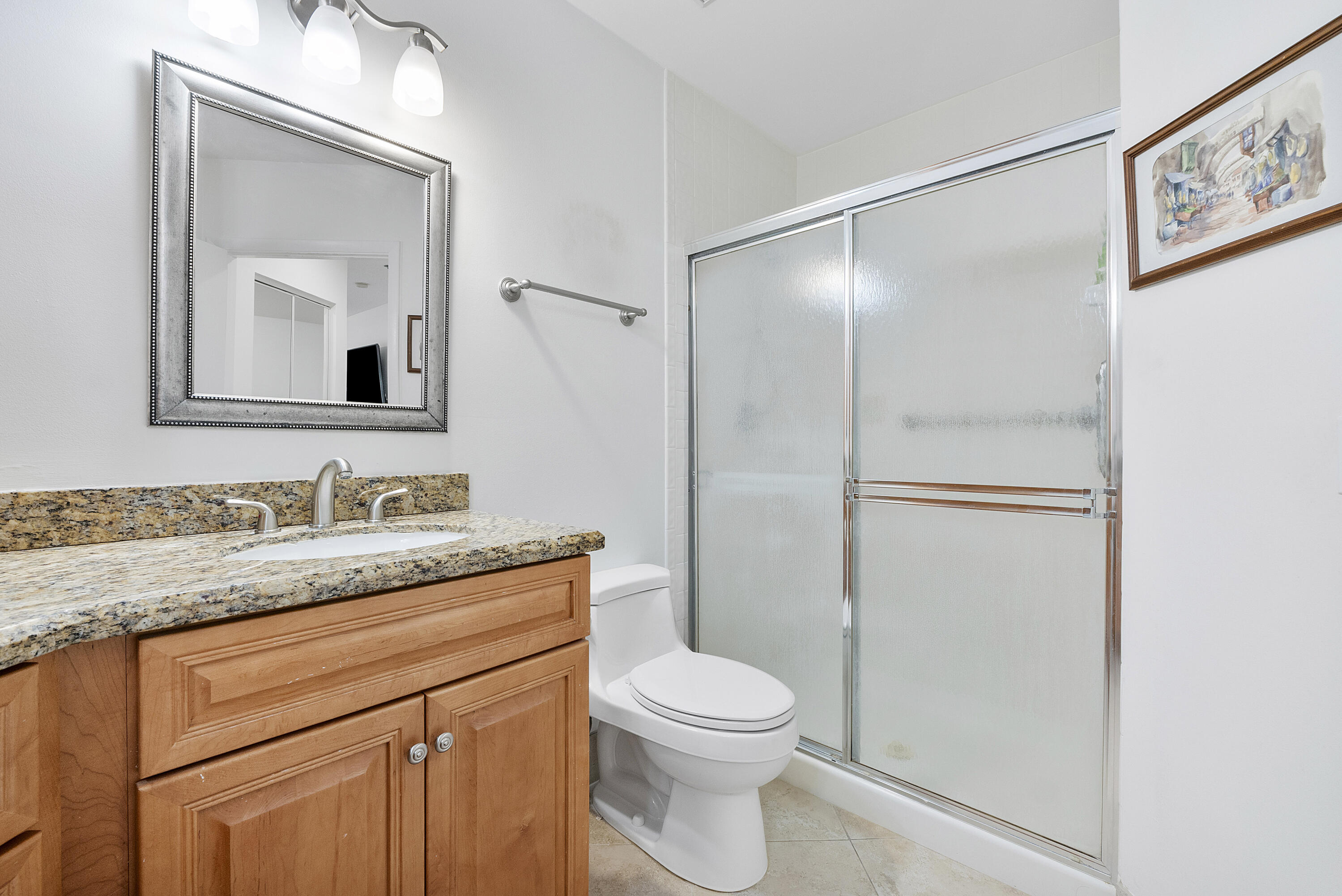 5153 Floria Drive, Unit V Boynton Beach, FL 33437 - Photo 16 of 39 a bathroom with a granite countertop sink mirror vanity and toilet