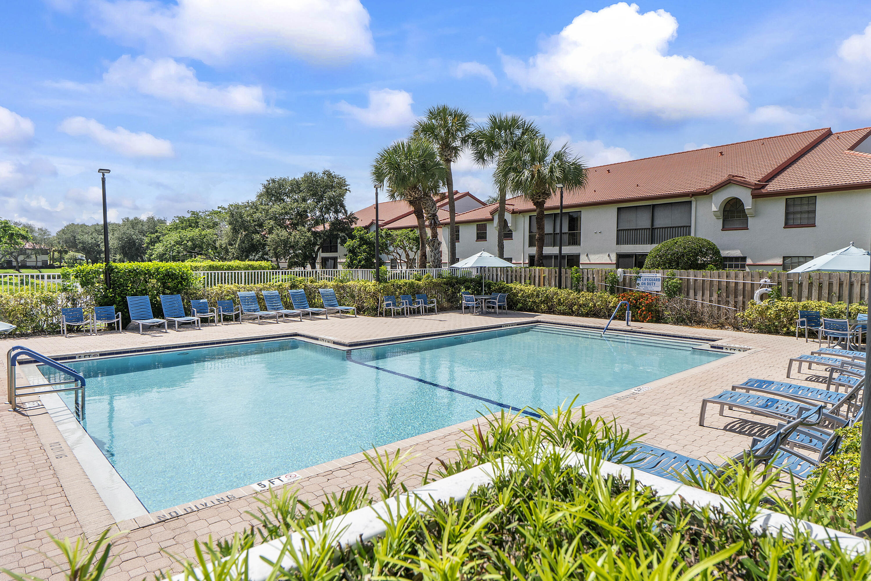 5153 Floria Drive, Unit V Boynton Beach, FL 33437 - Photo 32 of 39 a view of a swimming pool with a lounge chairs