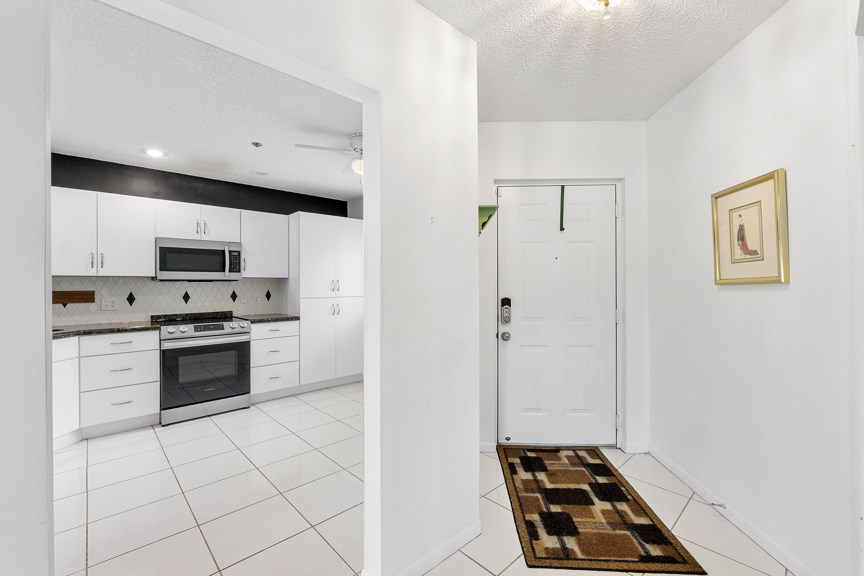 5153 Floria Drive, Unit V Boynton Beach, FL 33437 - Photo 9 of 39 a kitchen with white cabinets and appliances
