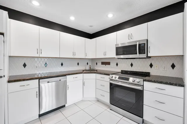 a kitchen with cabinets stainless steel appliances and a sink