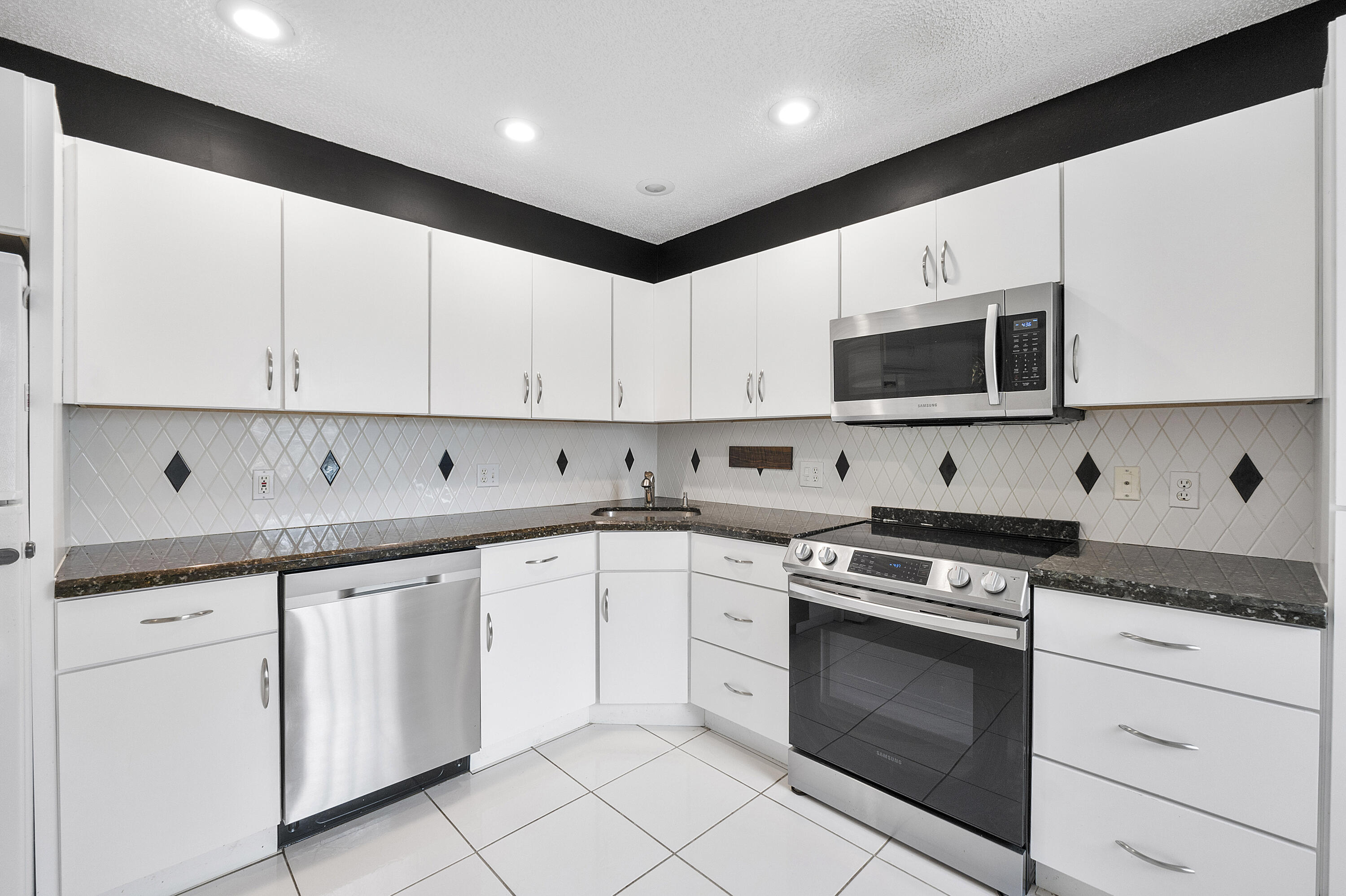 5153 Floria Drive, Unit V Boynton Beach, FL 33437 - Photo 10 of 39 a kitchen with cabinets stainless steel appliances and a sink