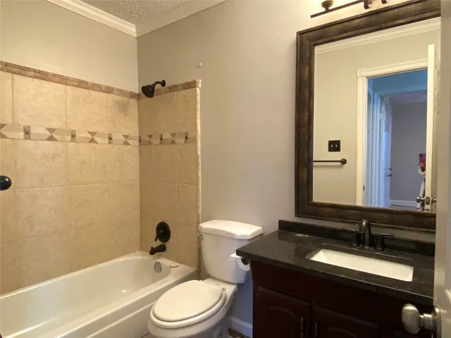 a bathroom with a granite countertop sink toilet a mirror and shower