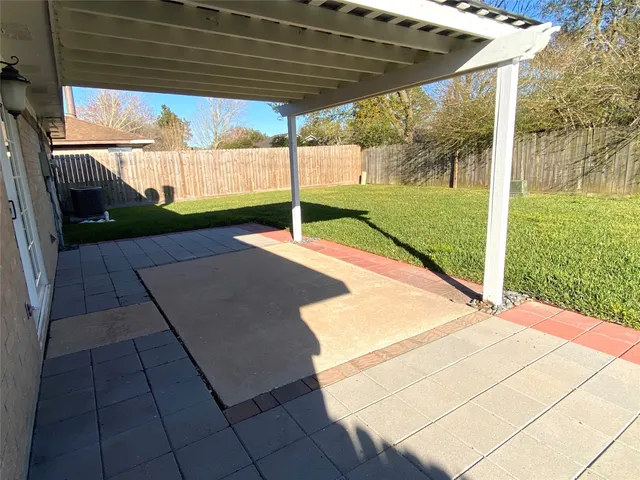 a view of a backyard with table and chairs under an umbrella