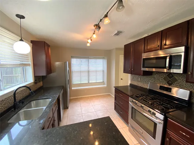 a kitchen with granite countertop a stove and a sink