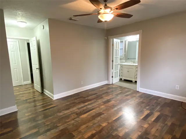 an empty room with wooden floor and mirror