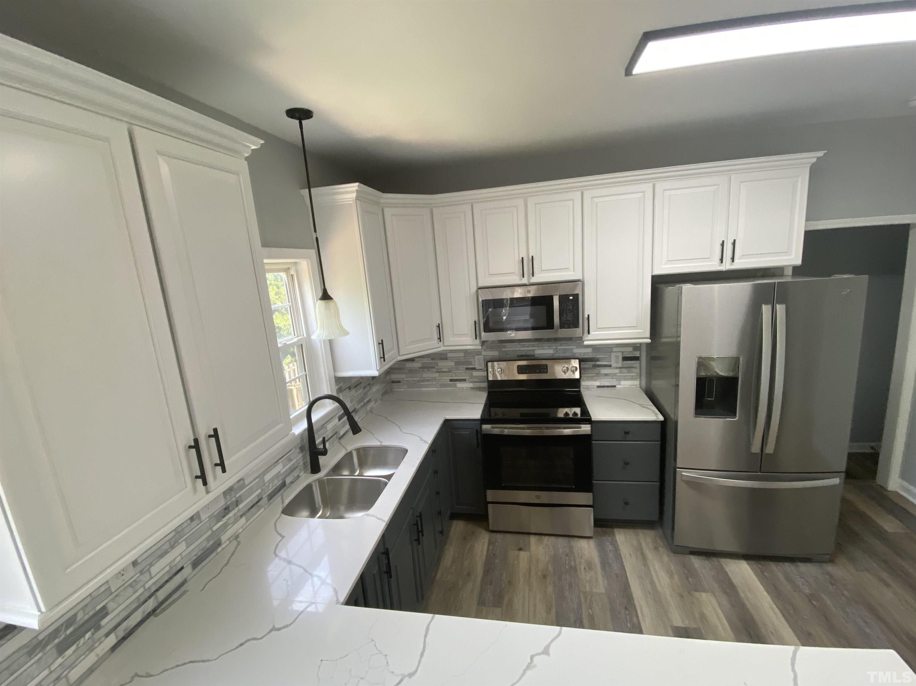 4815 Elmhurst Ridge Court Raleigh, NC 27616 - Photo 8 of 25 a kitchen with white cabinets and stainless steel appliances