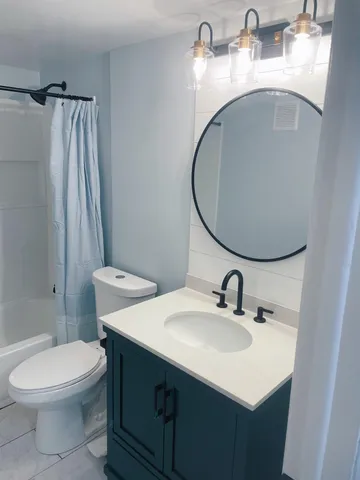 a bathroom with a sink toilet and mirror