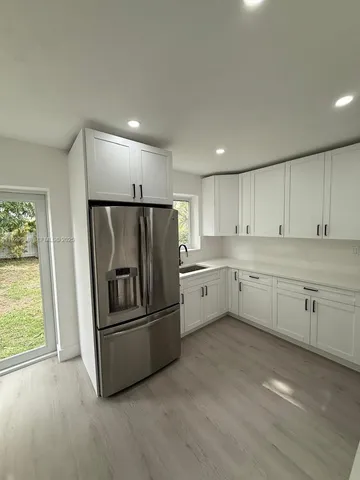 a kitchen with cabinets stainless steel appliances and window