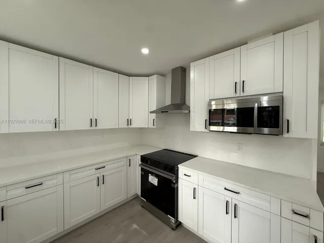 a kitchen with stainless steel appliances granite countertop white cabinets a sink and dishwasher