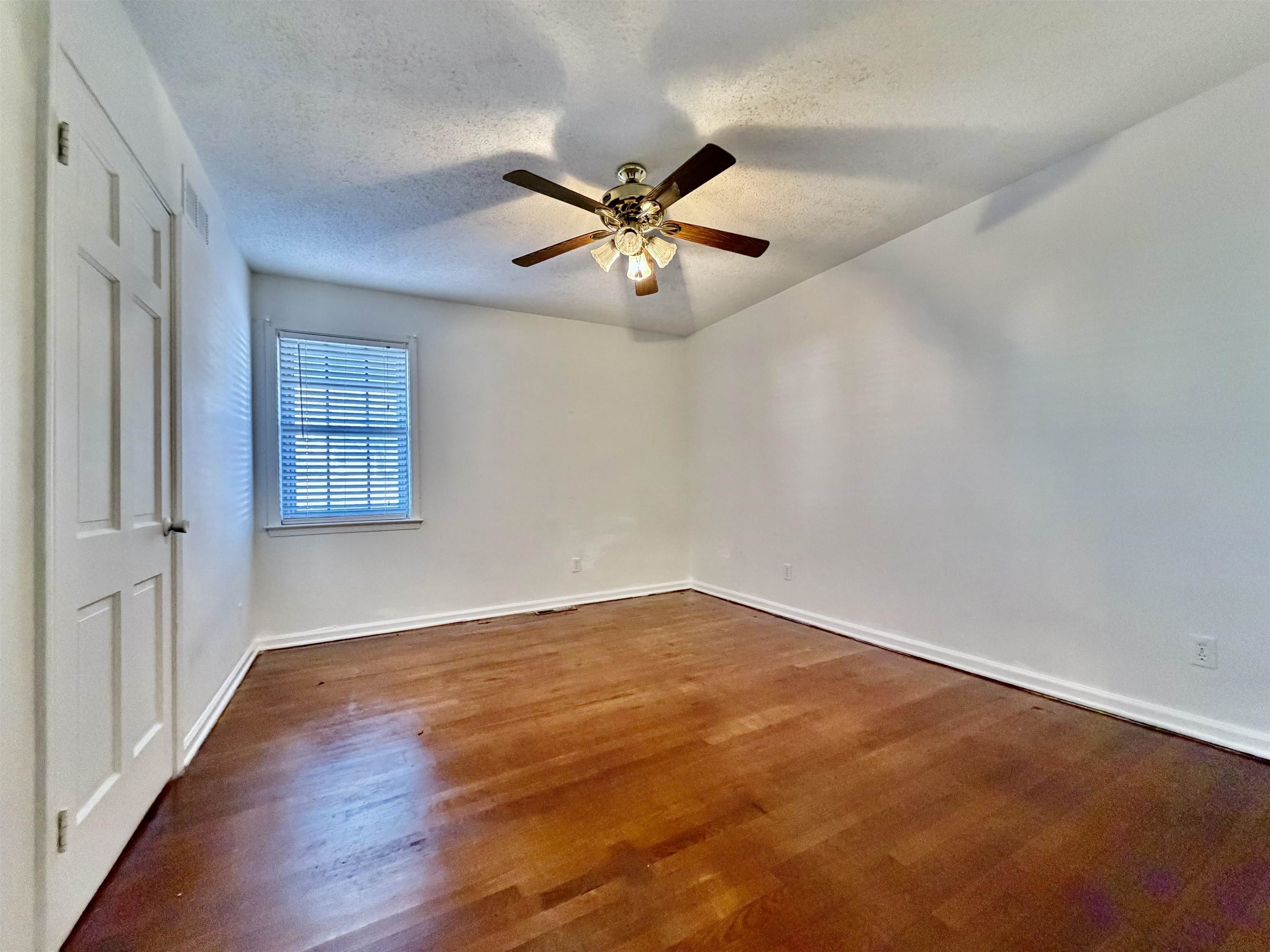3179 Coleman Road Memphis, TN 38128 - Photo 12 of 22 an empty room with wooden floor fan and windows