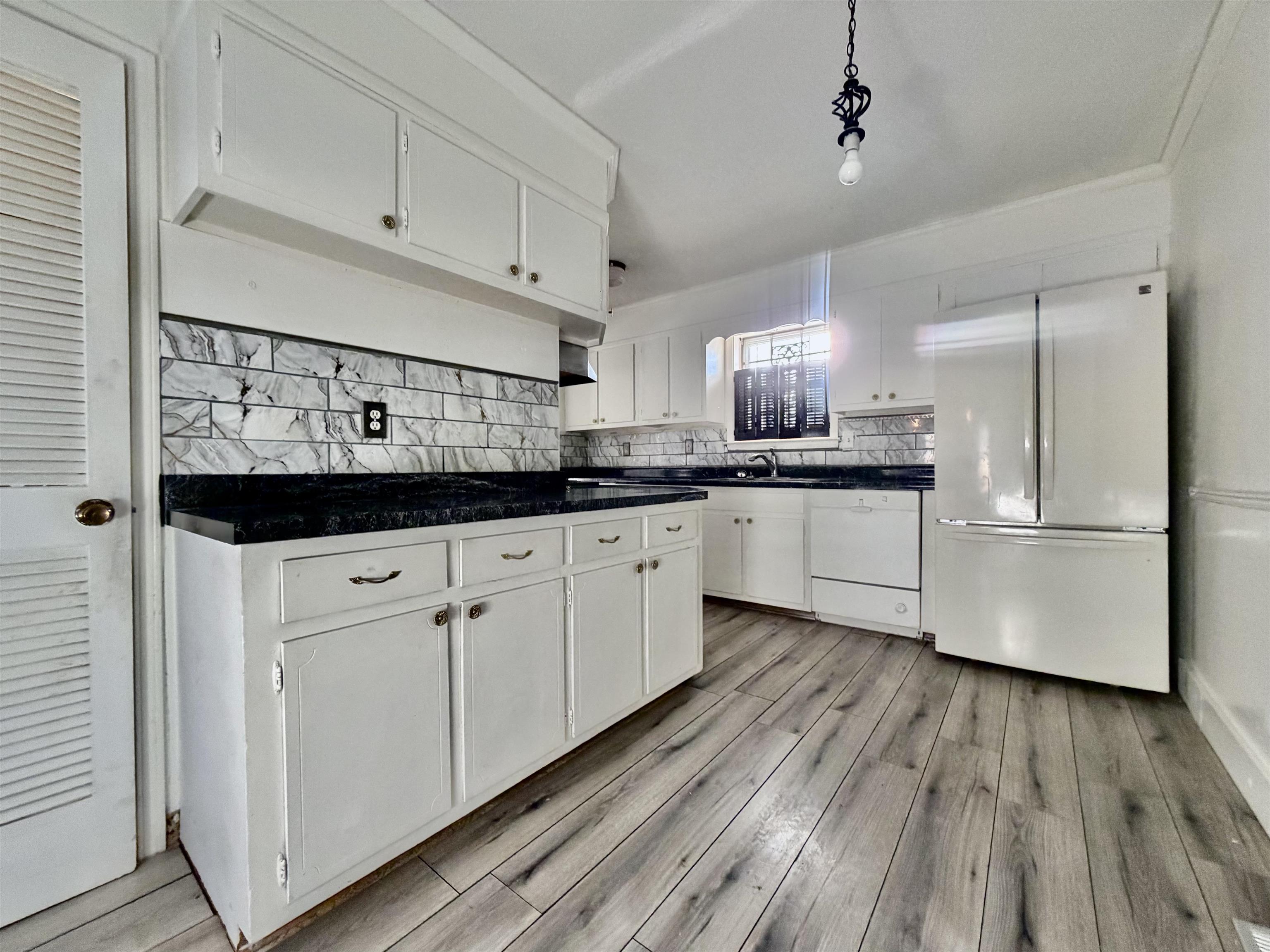3179 Coleman Road Memphis, TN 38128 - Photo 19 of 22 a kitchen with stainless steel appliances granite countertop a sink a stove and white cabinets with wooden floor