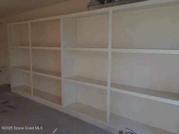 a view of walk in closet with empty racks