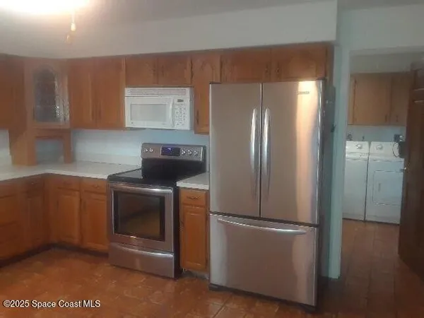 a kitchen with stainless steel appliances granite countertop a refrigerator and a stove top oven