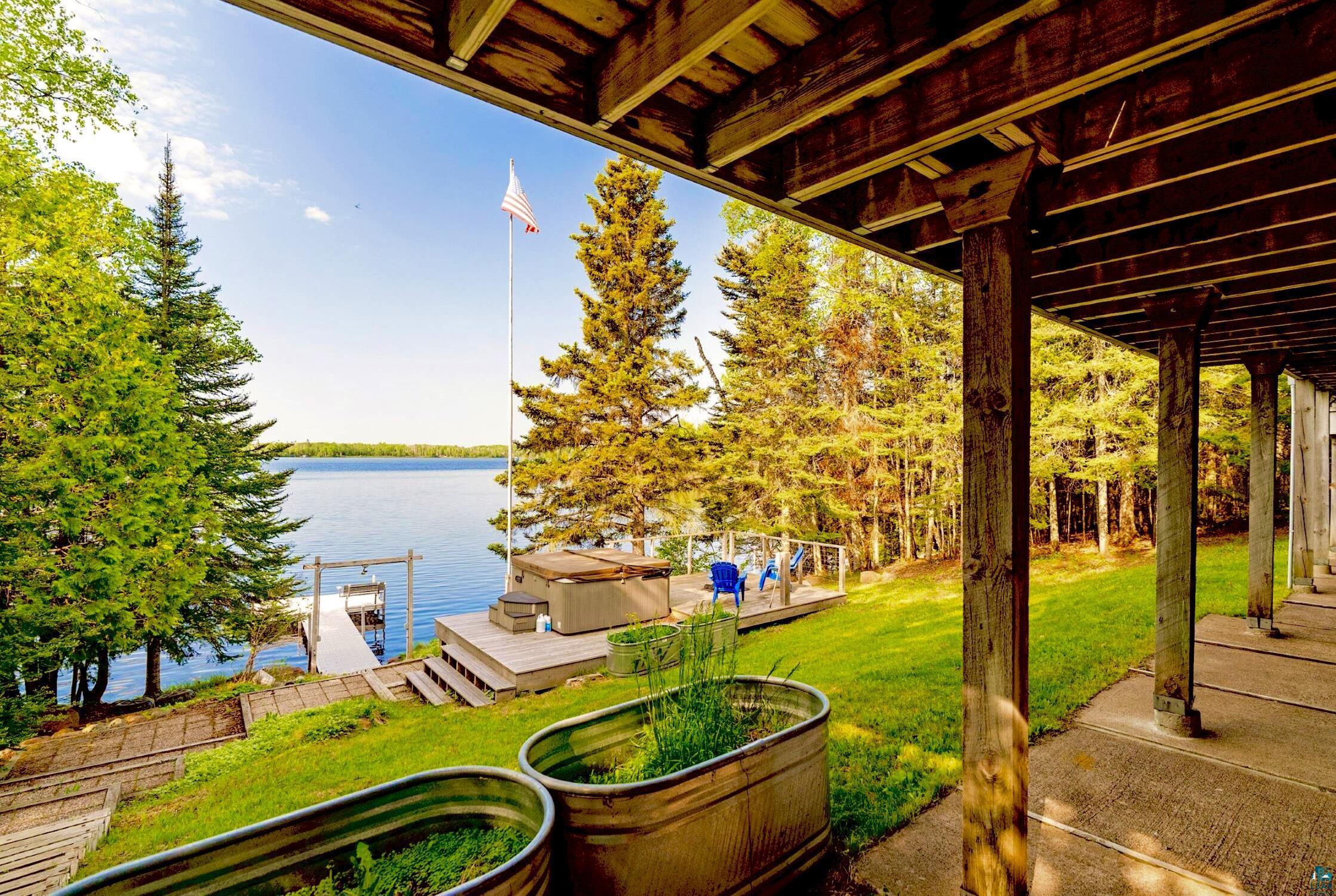 1480 Devil Track Road Grand Marais, MN 55604 - Photo 5 of 38 View of patio / terrace with a hot tub, a boat dock, and a deck with water view