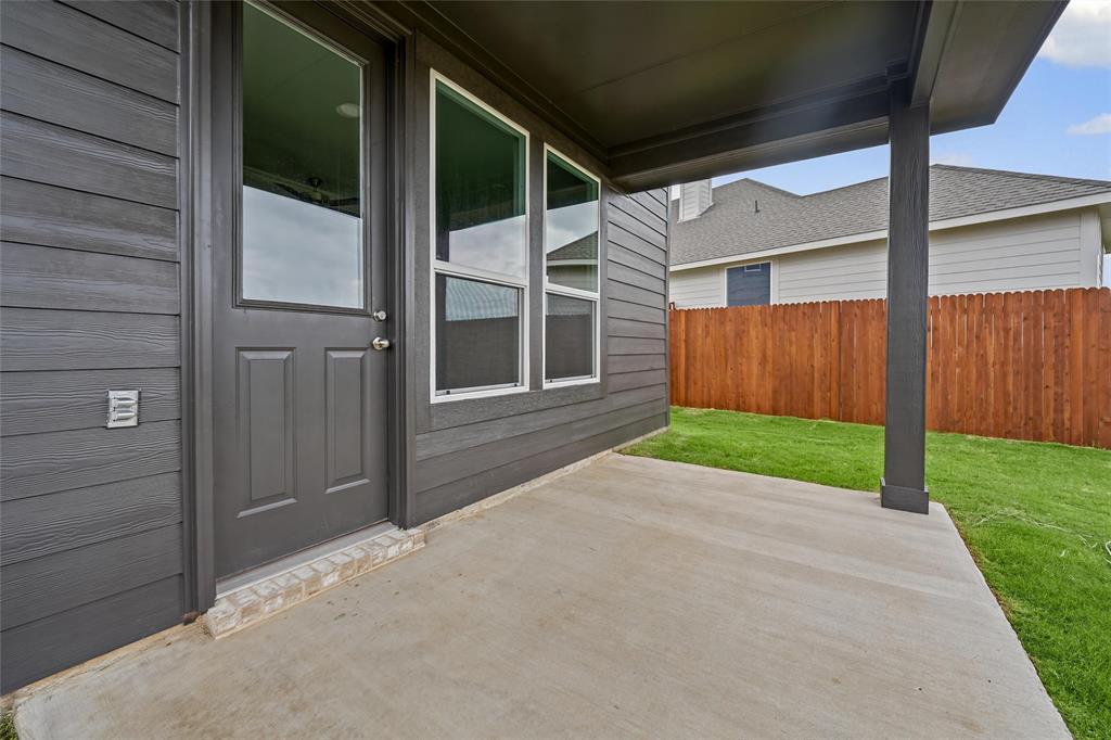 1205 Colca Drive Springtown, TX 76082 - Photo 32 of 37 Covered concrete patio with a full-light panel door, adjacent windows, and wood panel fencing