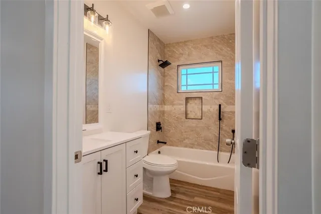 a bathroom with a bathtub shower sink vanity and a toilet