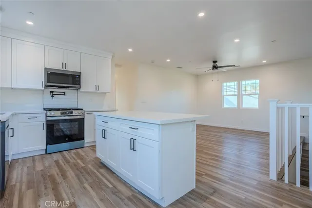a kitchen with stainless steel appliances a stove top oven a sink and a refrigerator