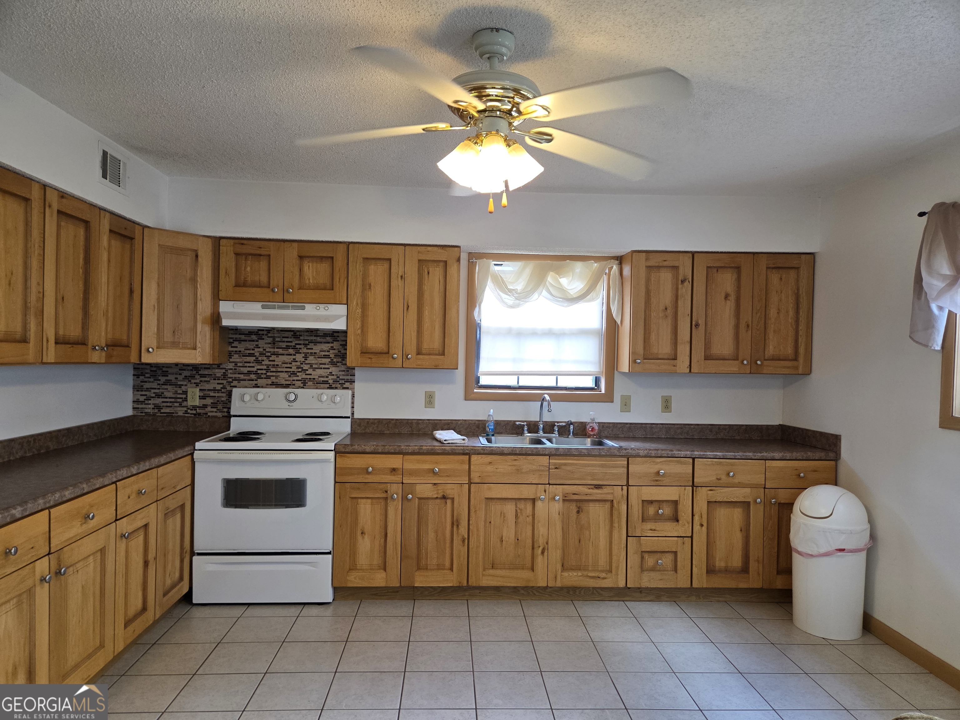 674 McNatt Falls Road Uvalda, GA 30473 - Photo 14 of 58 a kitchen with a stove sink and cabinets