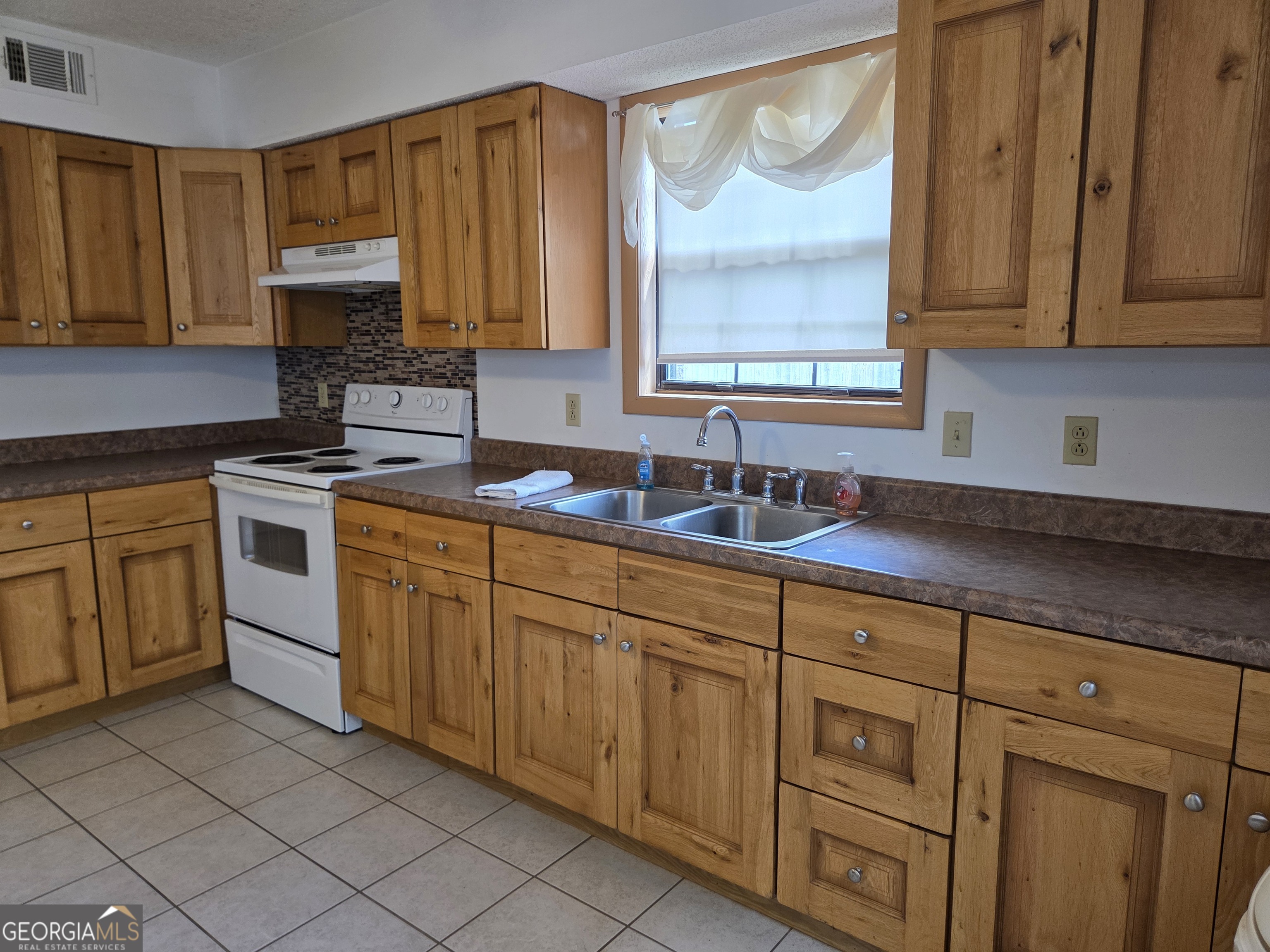 674 McNatt Falls Road Uvalda, GA 30473 - Photo 15 of 58 a kitchen with cabinets appliances a sink and a window