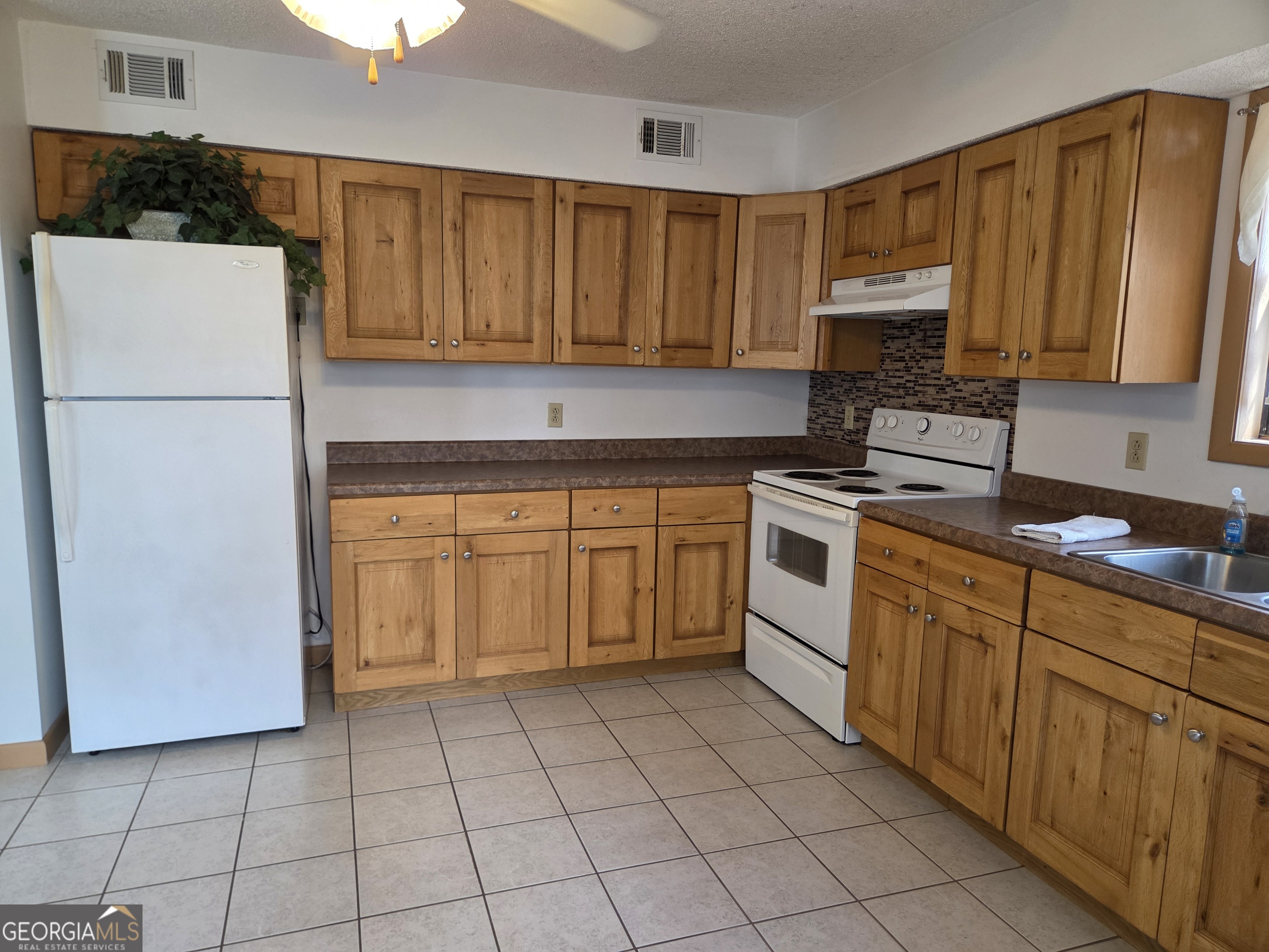 674 McNatt Falls Road Uvalda, GA 30473 - Photo 16 of 58 a kitchen with a stove sink and cabinets