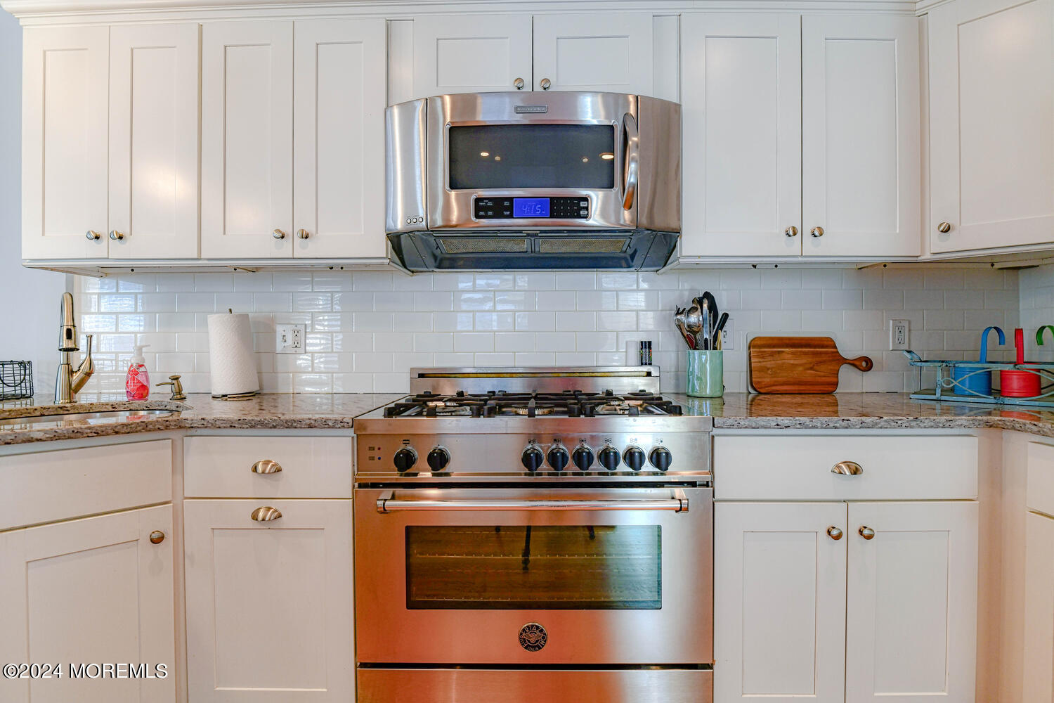 94 Clark Avenue Ocean Grove, NJ 07756 - Photo 14 of 29 a kitchen with stainless steel appliances granite countertop a stove and white cabinets
