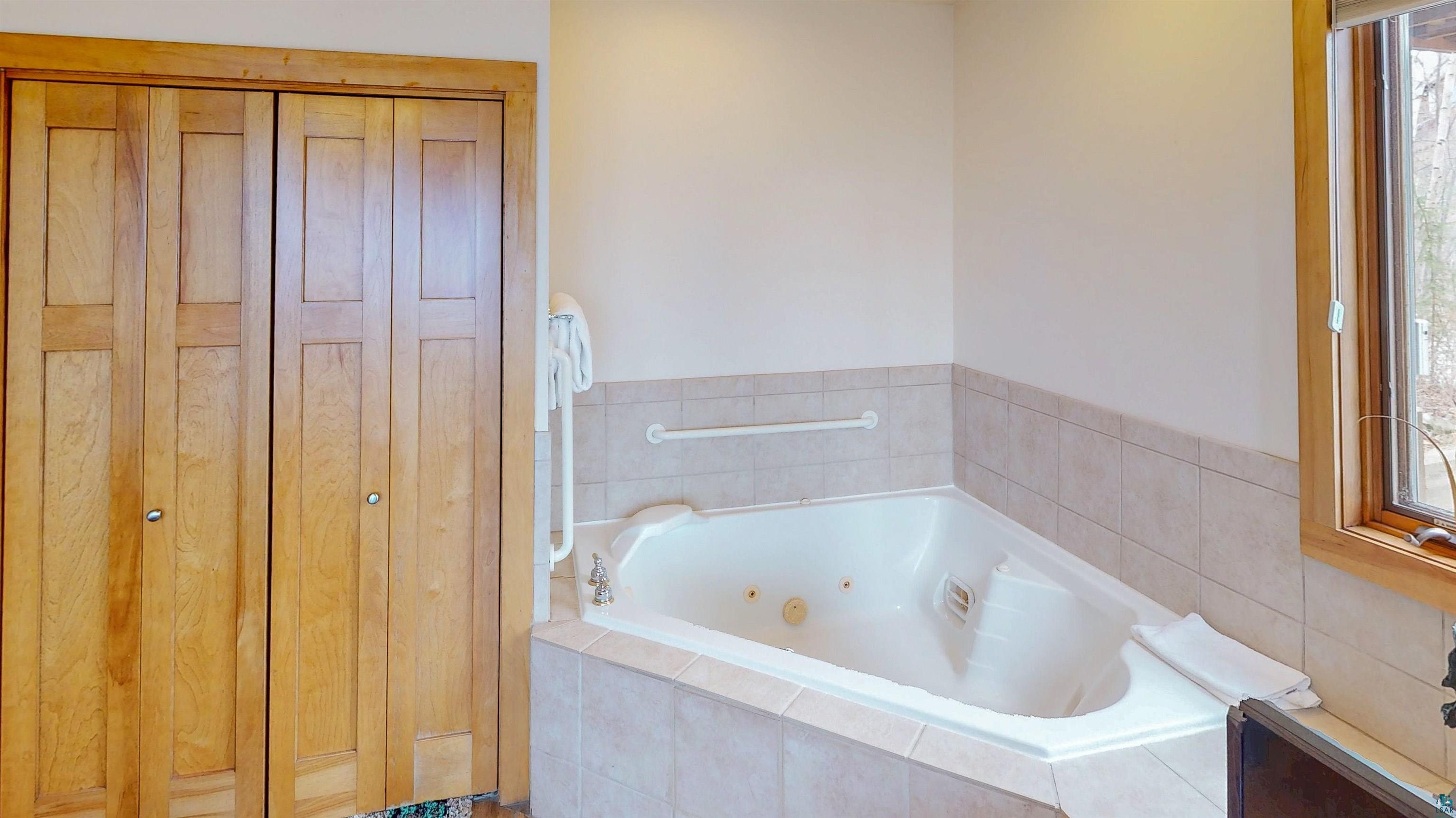 504-506 Poplar River Road, Unit 505 Lutsen, MN 55612 - Photo 14 of 39 Corner soaking tub with tiled surround and integrated jets