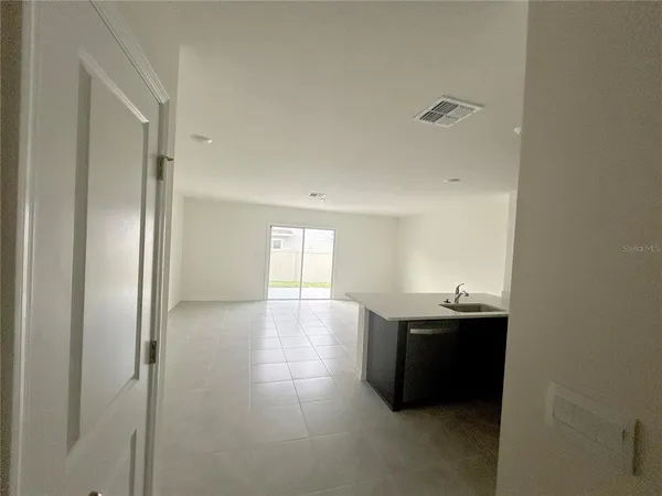 a view of an empty room with window and closet area