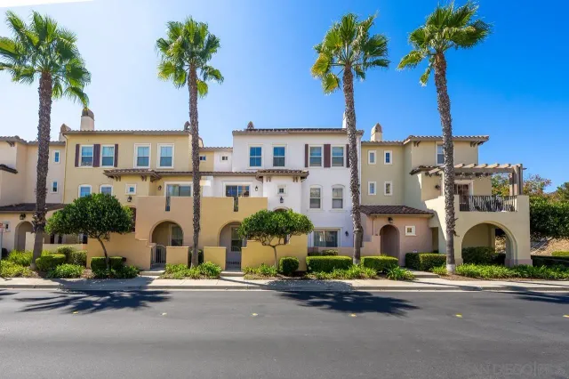 a front view of multiple houses with yard