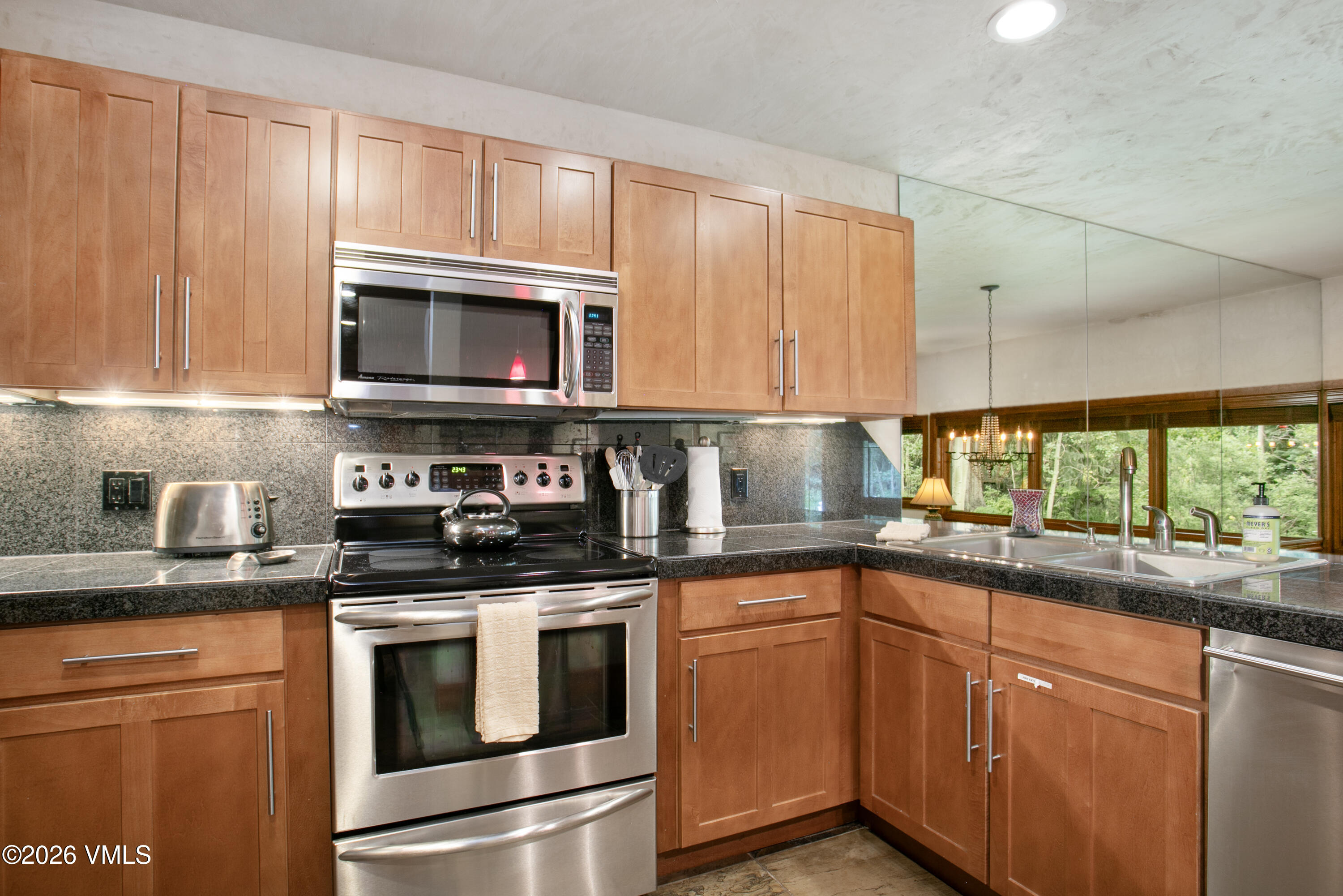 3911 Big Horn Road, Unit 1B Vail, CO 81657 - Photo 2 of 29 a kitchen with granite countertop cabinets stainless steel appliances a sink and window