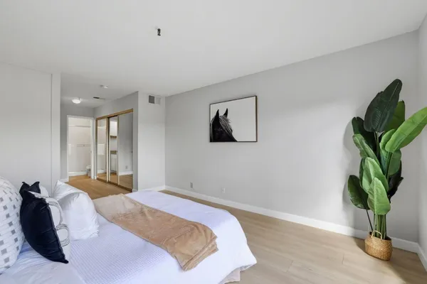 a bedroom with bed and a potted plant