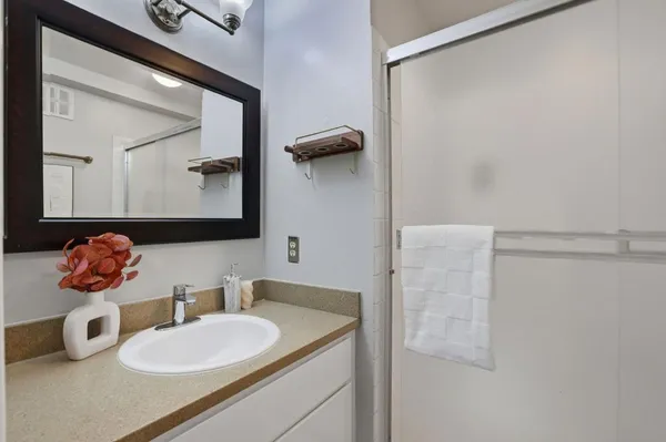 a bathroom with a granite countertop sink and a mirror