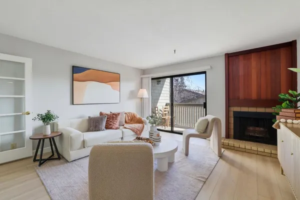 a living room with furniture a fireplace and a floor to ceiling window