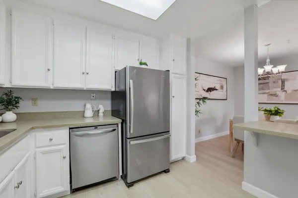 a kitchen with stainless steel appliances white cabinets and a refrigerator