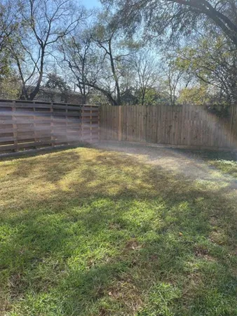 a view of a yard with wooden fence