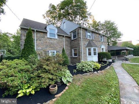 1201 Knox Road Wynnewood, PA 19096 - Photo 5 of 49 a front view of a house with a yard and potted plants