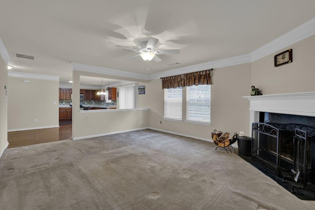 3160 Centerglen Lane Cumming, GA 30040 - Photo 20 of 40 a view of a livingroom with a fireplace a ceiling fan and windows